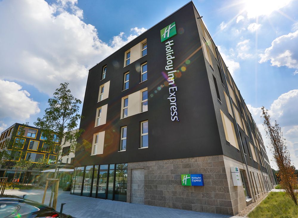 Holiday Inn Express Karlsruhe – dunkle Fassade mit vertikalem Markenschriftzug